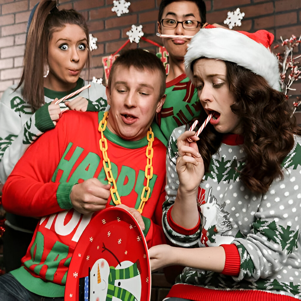 Four young adults in festive Christmas sweaters making funny faces and eating candy canes.