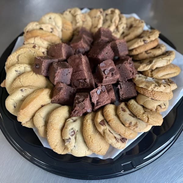 A black platter filled with chocolate chip cookies and fudge brownies from eats & sweets bakery.